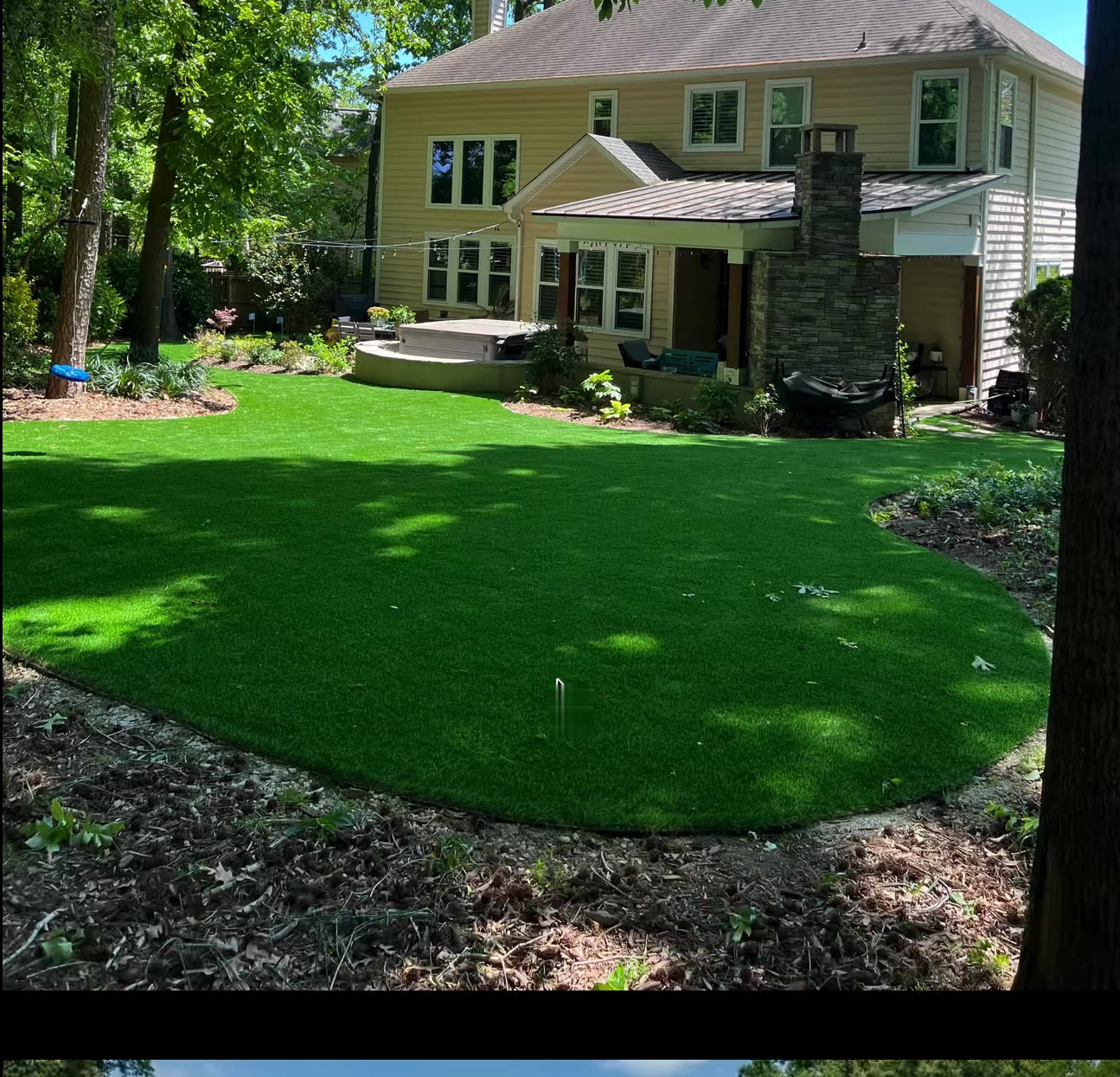 Full backyard turf lawn behind a two-story home